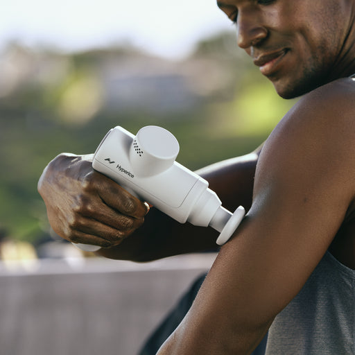 A man using the Hypervolt Go 2 Percussion Handheld Massager on his arm